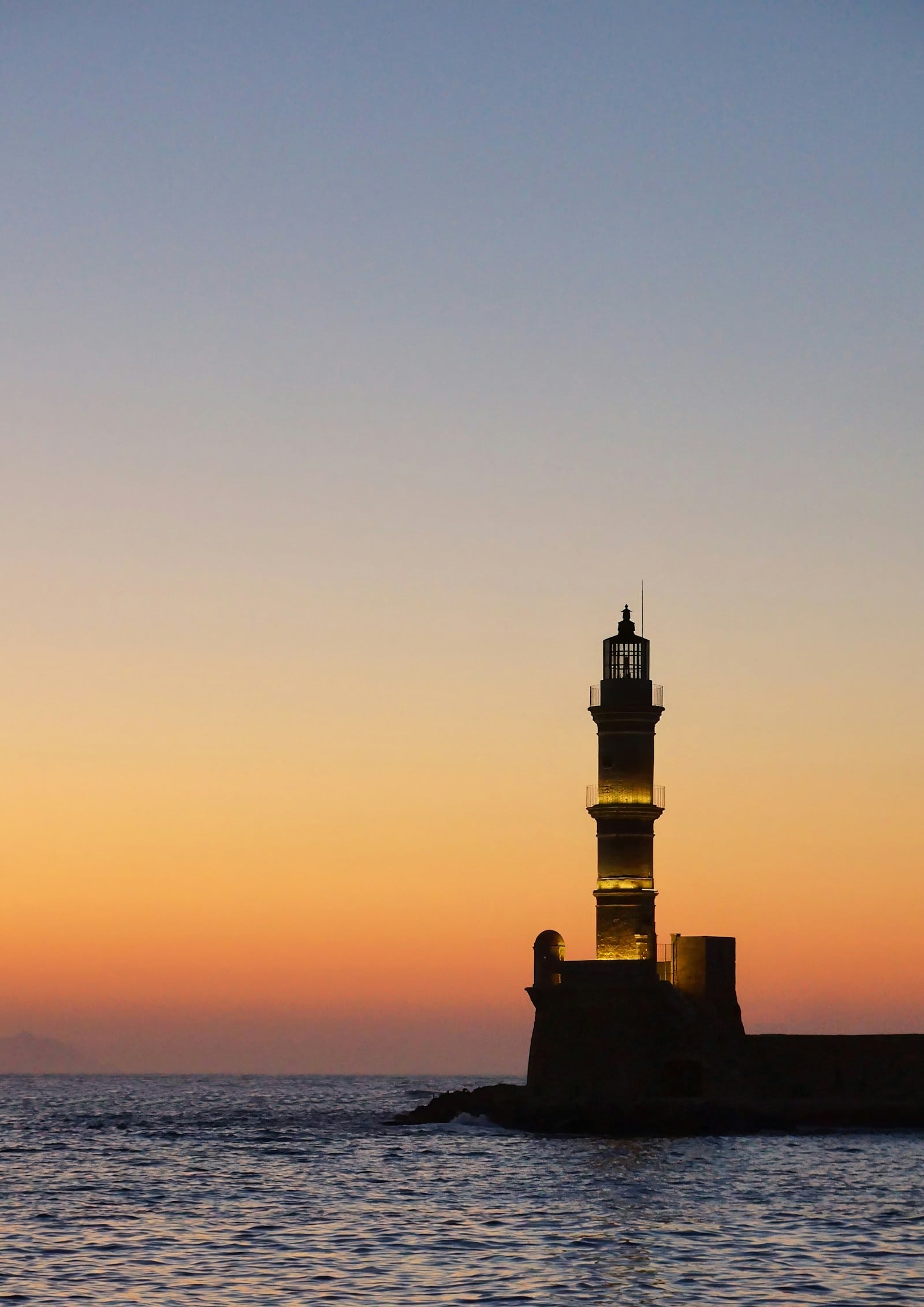 Chania lighthouse above the sea at sunset in Crete, Greece